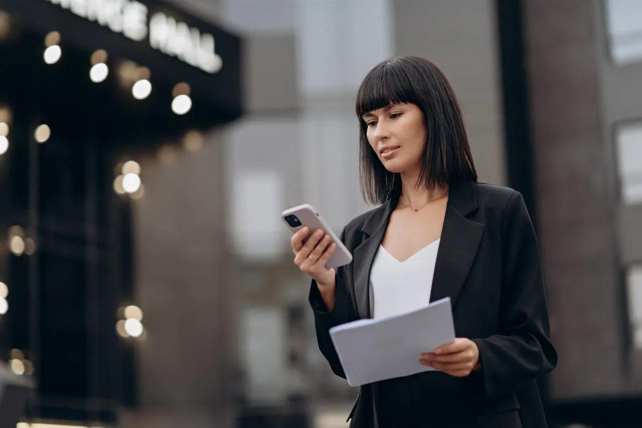 Professional reviewing calendar and tasks on a smartphone while walking
