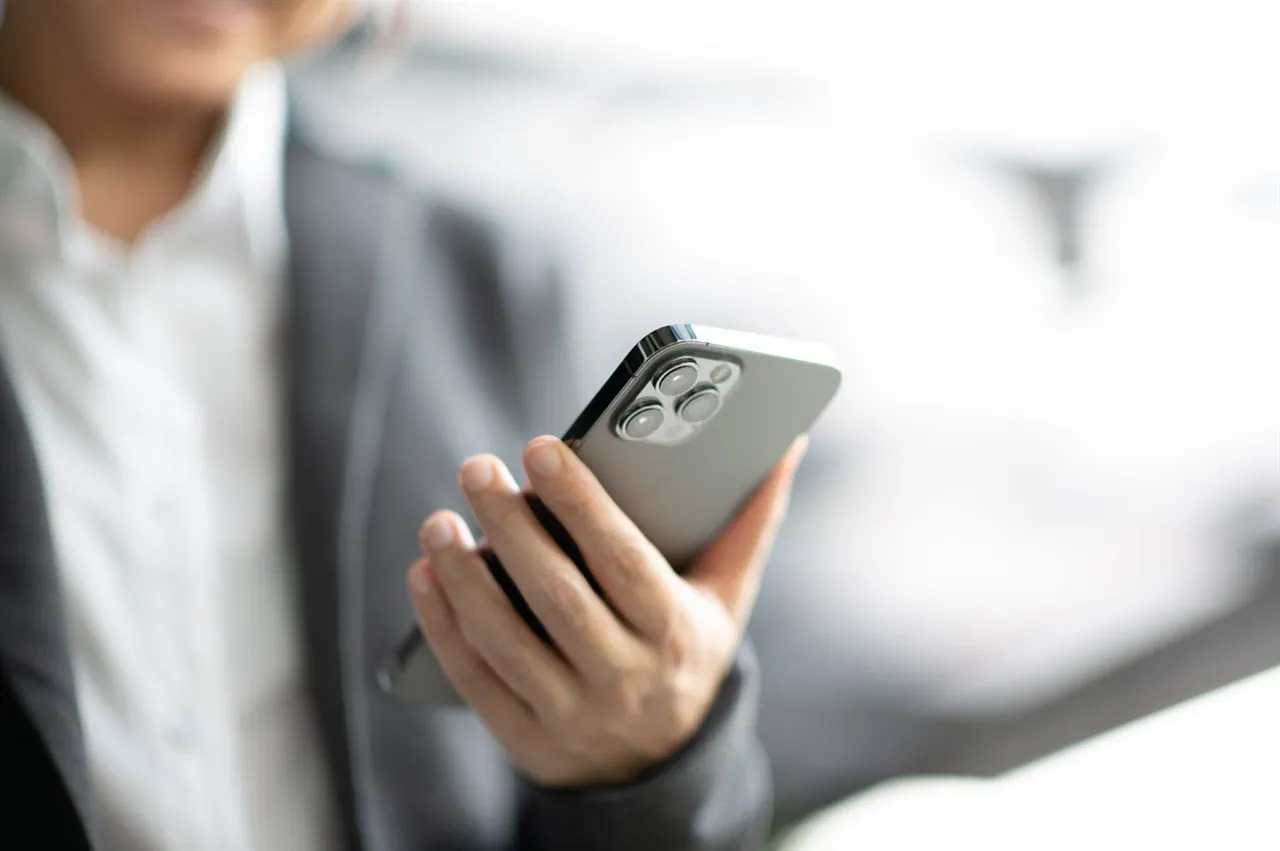 Professional holding a smartphone with RealNex Mobile app open