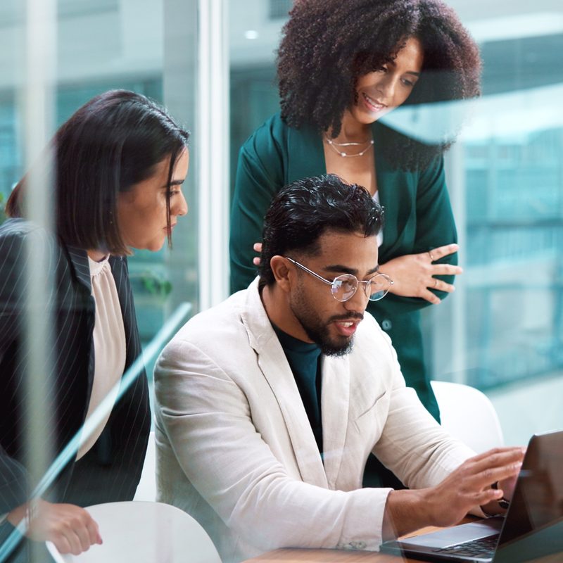 Marketing team collaborating around a laptop
